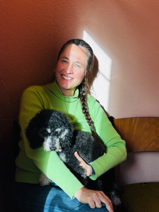 Barbara Pulfer sitzt lächelnd mit Polli auf dem Schoß