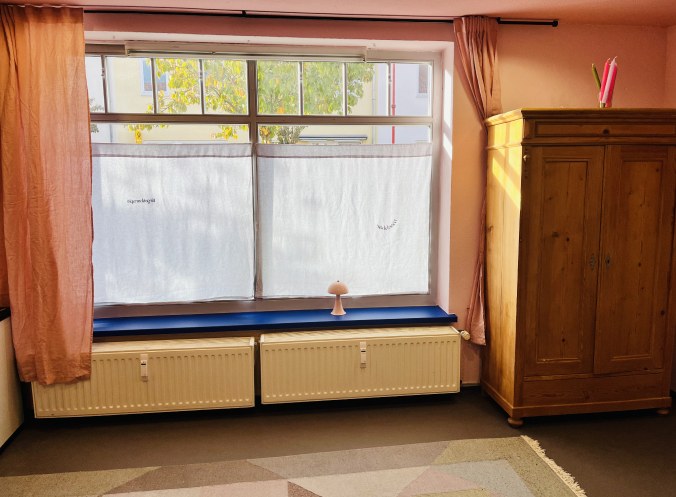 Praxisraum mit großem Fenster und Holzschrank